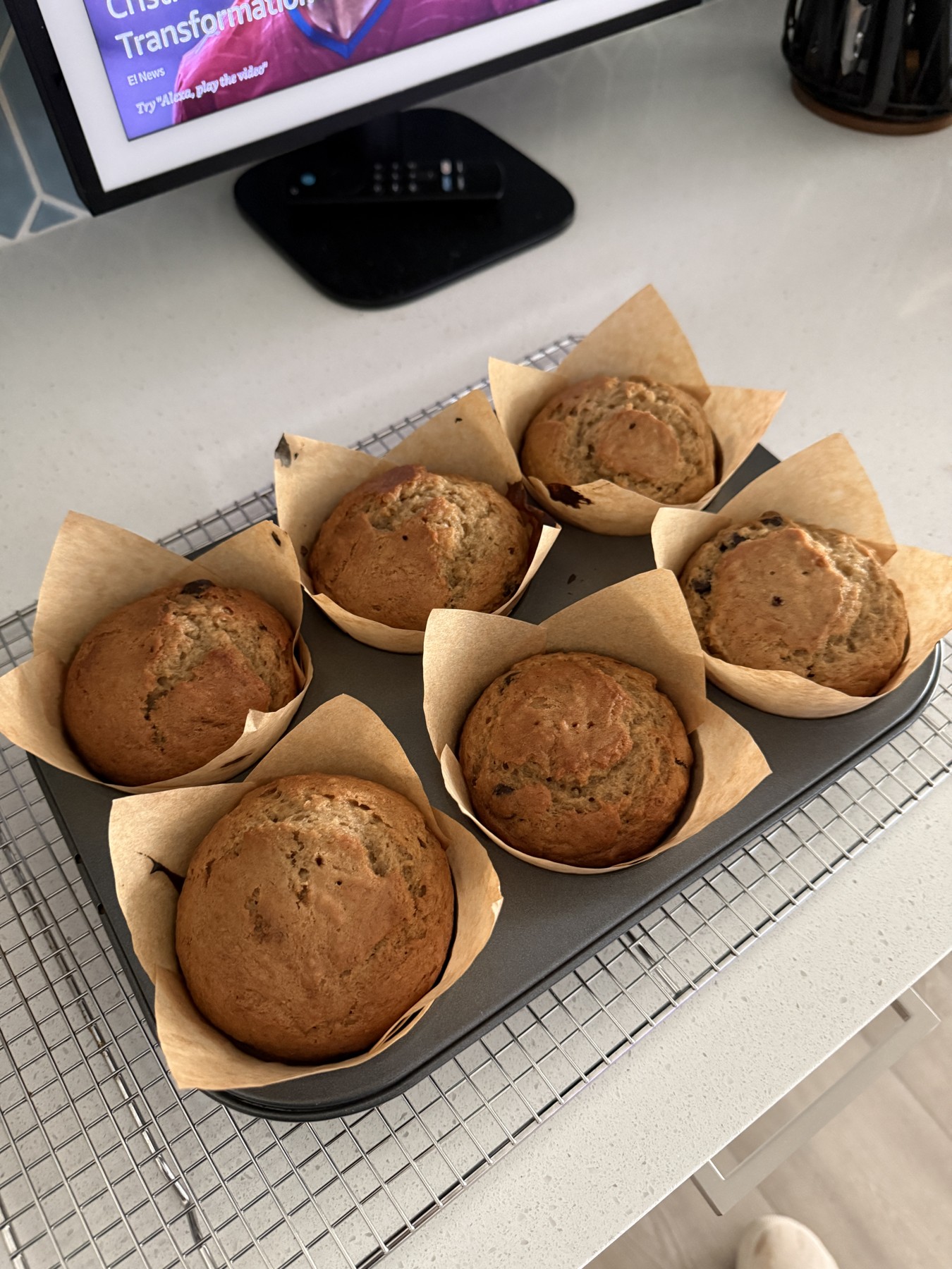 Homemade muffins cooling in a tray lined with parchment paper