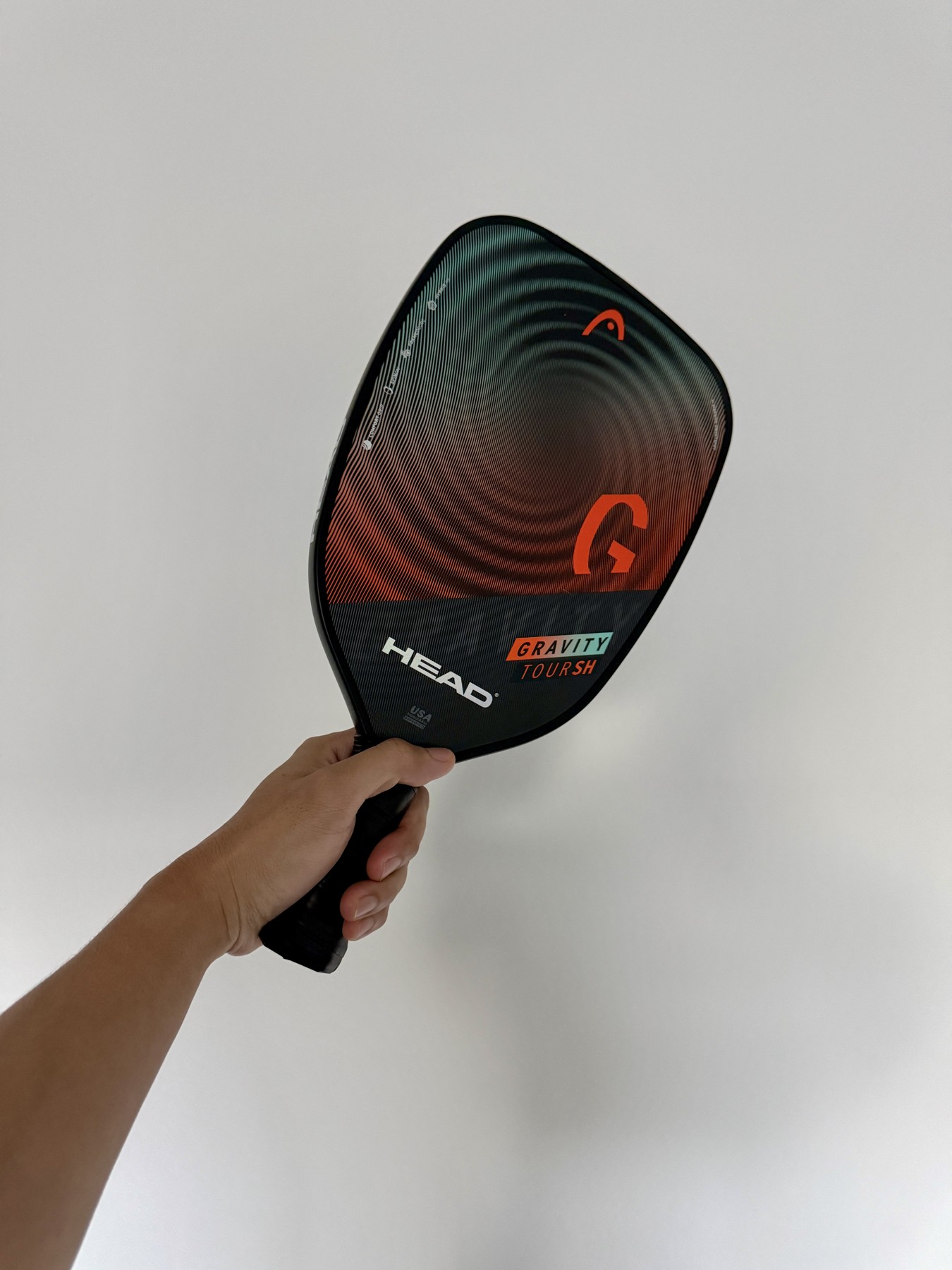 My hand holding a pickleball paddle